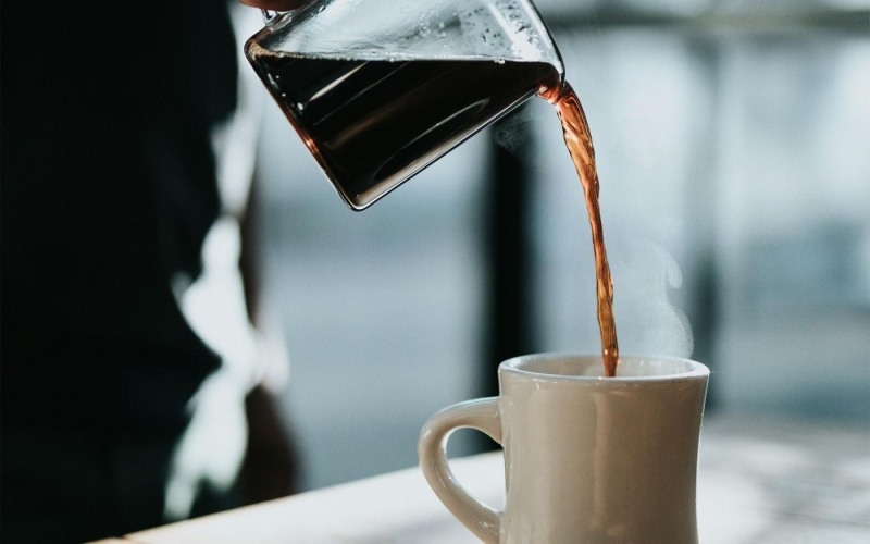 Settle into comfort at Aspendale Northglenn a person pouring a carafe of coffee into a cup