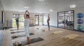 a group of people exercising in a fitness studio with large windows