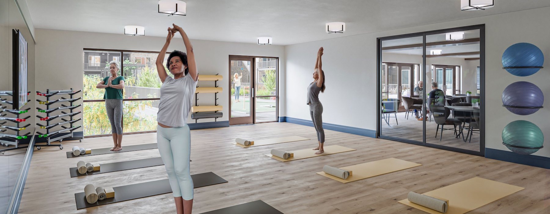 a group of people exercising in a fitness studio with large windows
