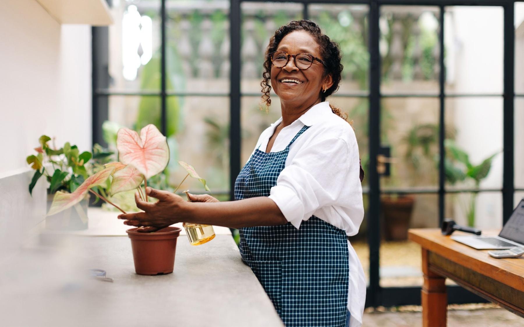 Woman arranging flowers in a well lit shop