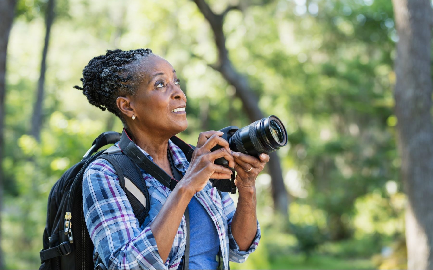 a woman outside holding a camera