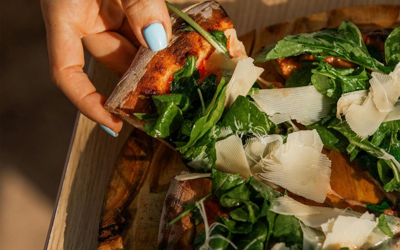 a person holding a slice of pizza