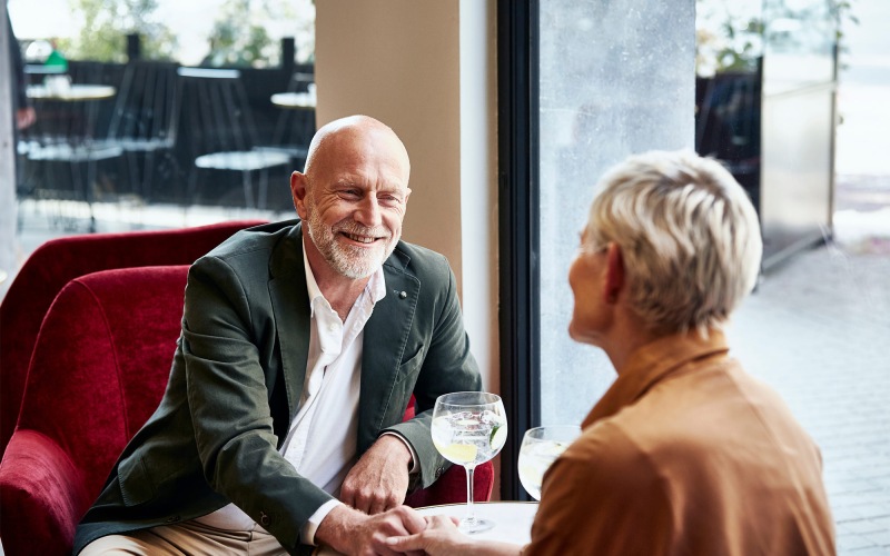a man and a woman sitting at a table with cocktails