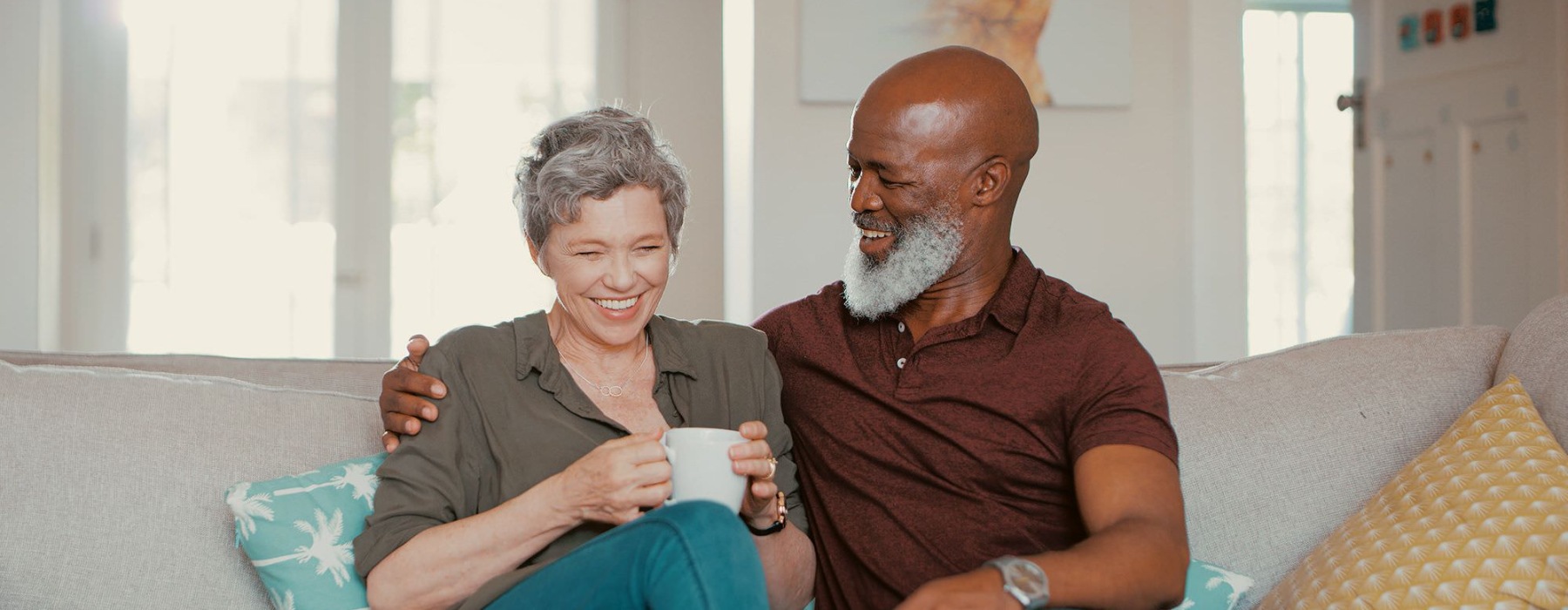 smiling, older couple, sit together on a couch